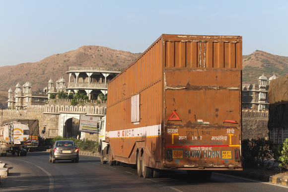Large trailer and car on the highway on the outskirts of Udaipur