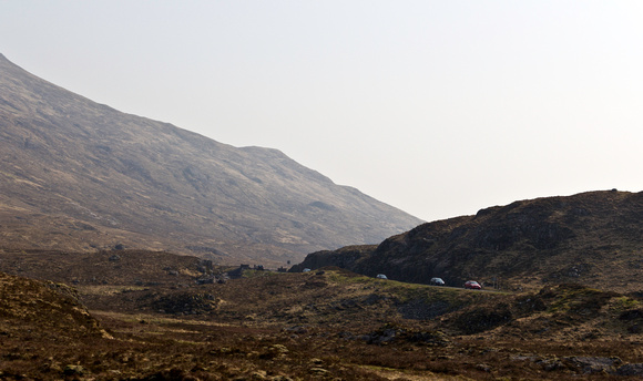 Cars on a road in the rugged wilderness of the Scottish Highland