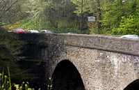 Cars crossing a stone bridge over the River Teith, near the town
