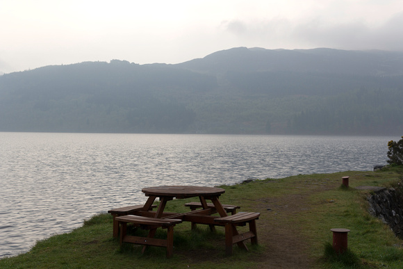 Wooden table and chairs at the shore of Loch Ness in Scotland