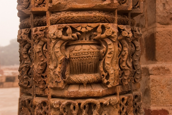 A stone pillar with beautiful carvings inside the Qutub Minar complex
