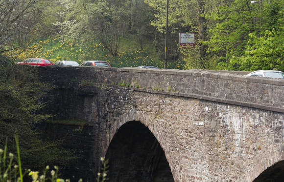 Cars crossing a stone bridge over the River Teith, near the town