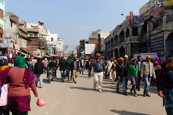 Shops and devotees in a crowded street in front of the Golden Te