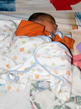 Newborn baby boy sleeping covered with a blanket