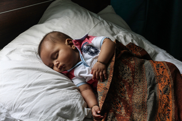 Indian infant boy sleeping peacefully with a shawl covering him
