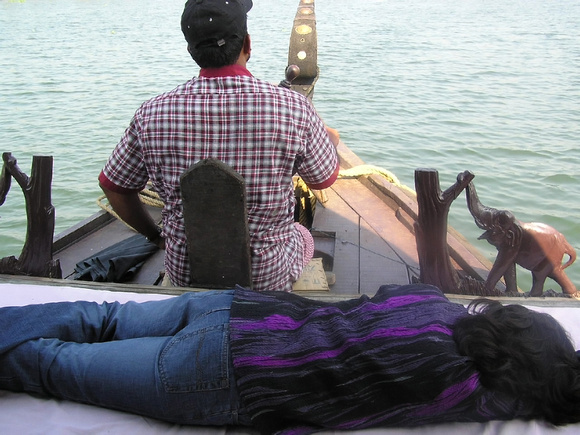 Lady sleeping while boatman steers